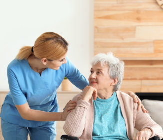 a caregiver and an elderly woman both smiling