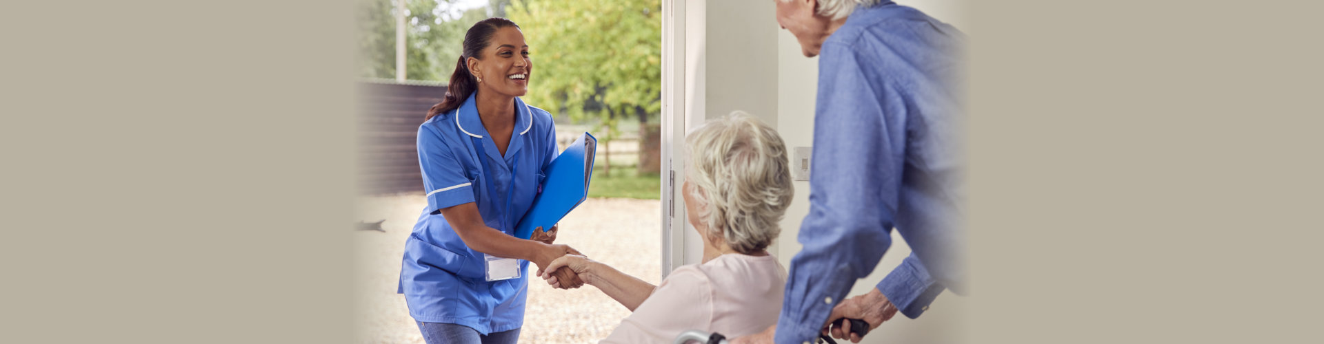 carer welcoming an elder couple